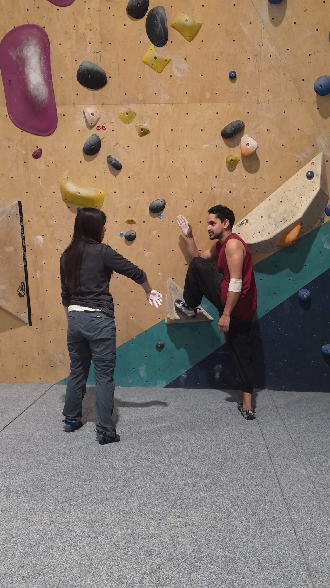 Kamran coaching a student at the climbing wall
